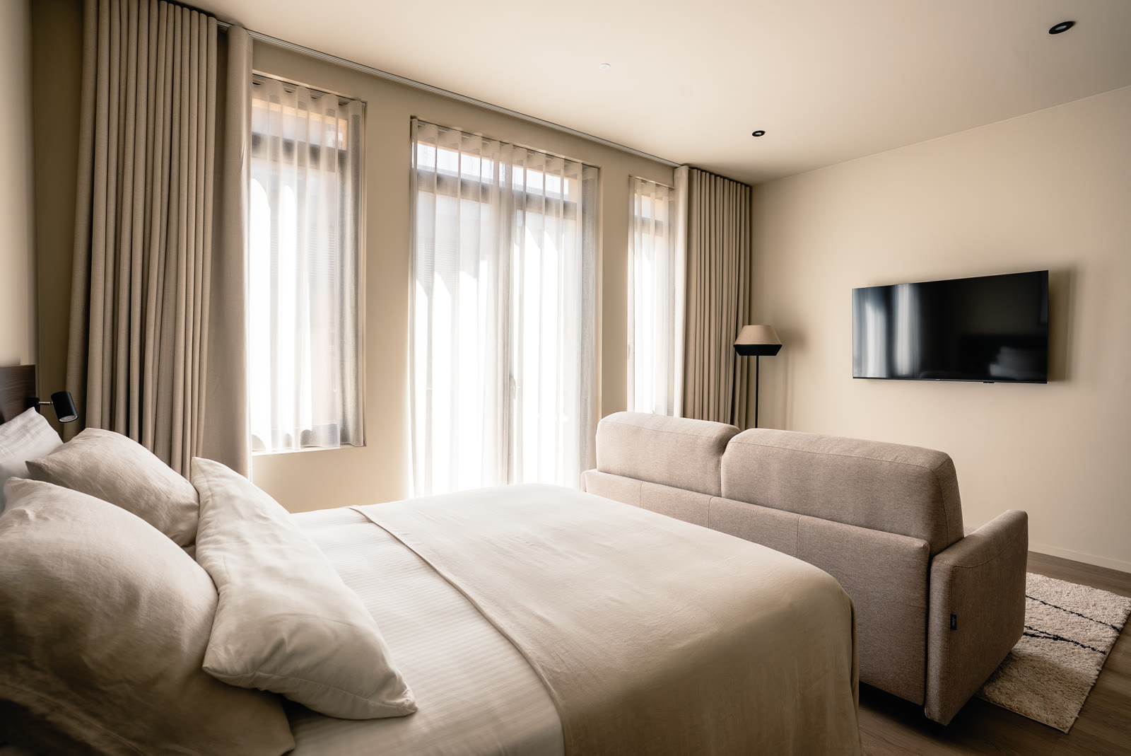 A calm, contemporary guest room photographed for RAIBU and STAY-C