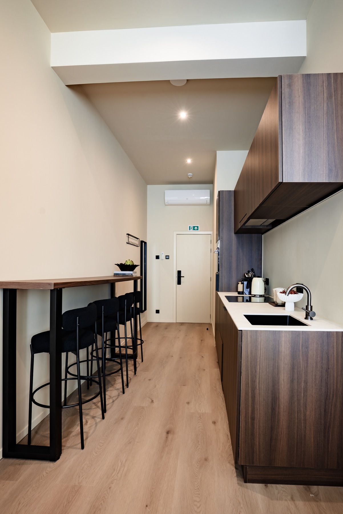 A compact kitchen and dining counter inside a RAIBU studio